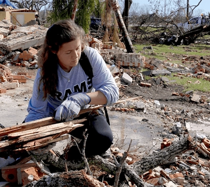 student cleaning up debris